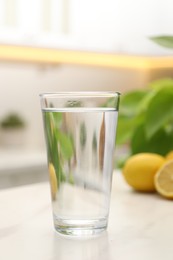 Glass with clear water on white table in kitchen