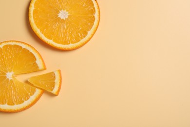 Photo of Slices of juicy orange on beige background, flat lay. Space for text