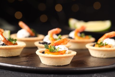 Delicious canapes with shrimps and black caviar on table, closeup