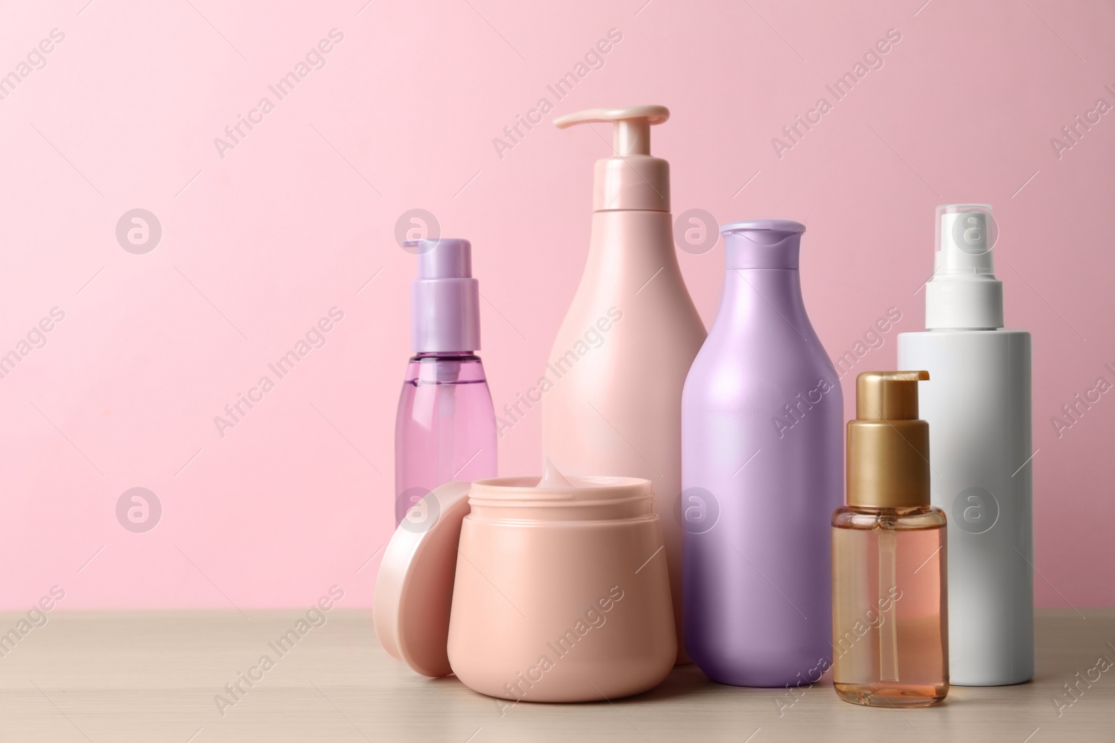 Photo of Different hair care products on wooden table