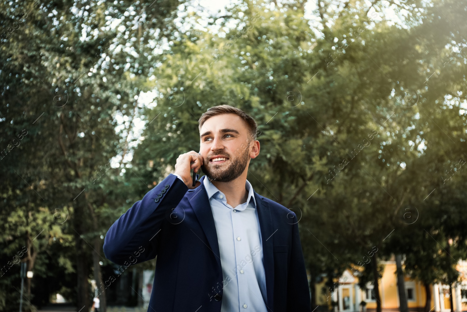 Photo of Young man talking on smartphone in park