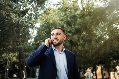 Young man talking on smartphone in park