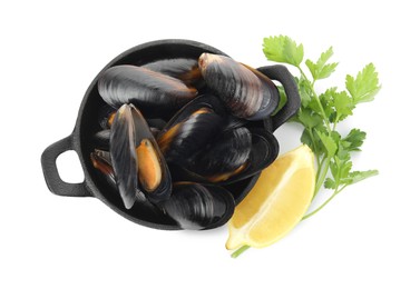 Pan of cooked mussels with parsley and lemon on white background, top view
