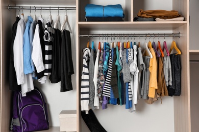 Photo of Wardrobe with stylish boy's clothes hanging on rack