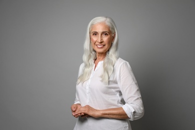 Photo of Portrait of beautiful mature woman on grey background