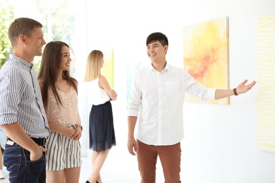 Group of people with guide at exhibition in art gallery