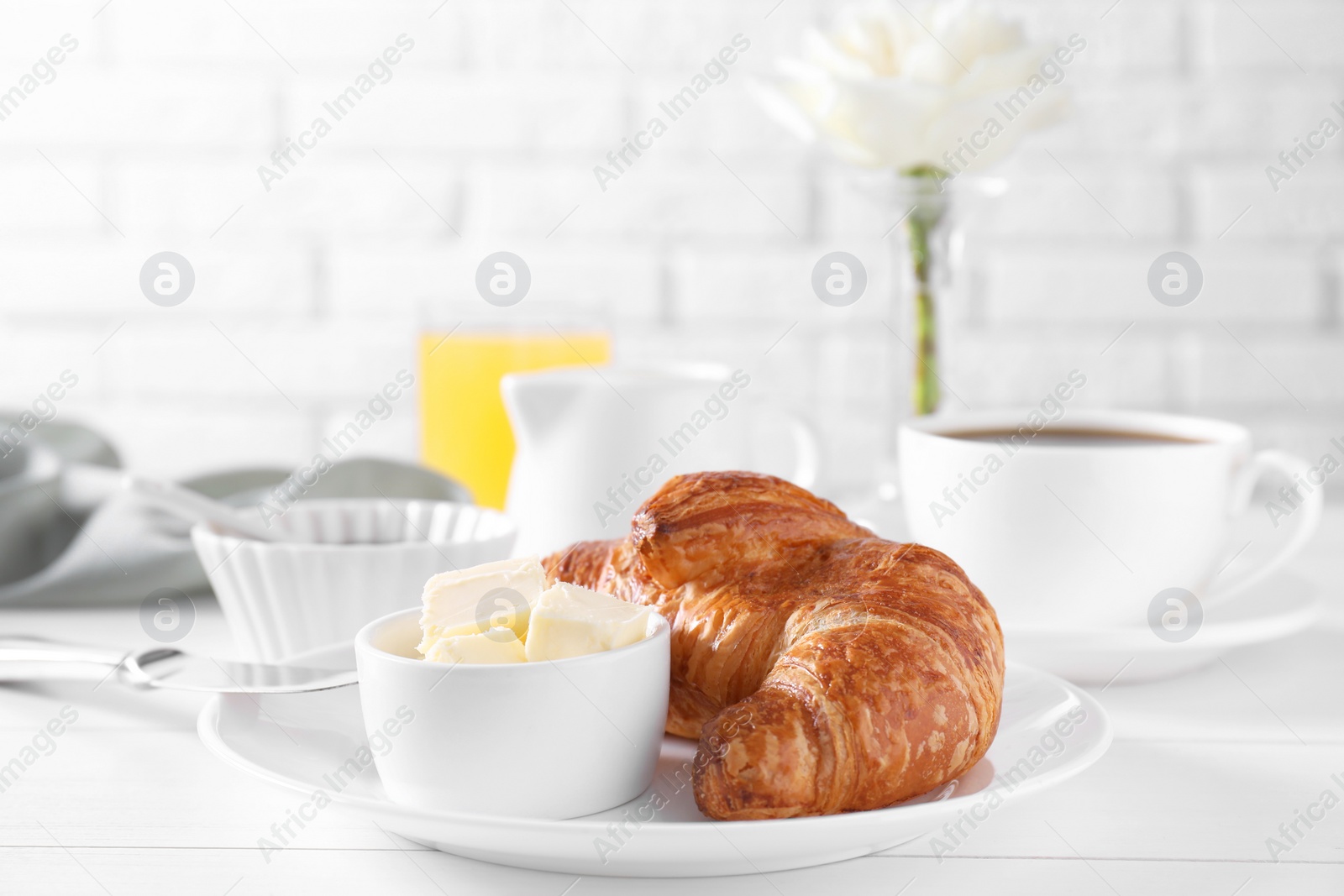 Photo of Fresh croissant and butter on white wooden table. Tasty breakfast