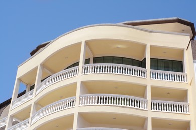 Exterior of beautiful residential building with balconies against blue sky