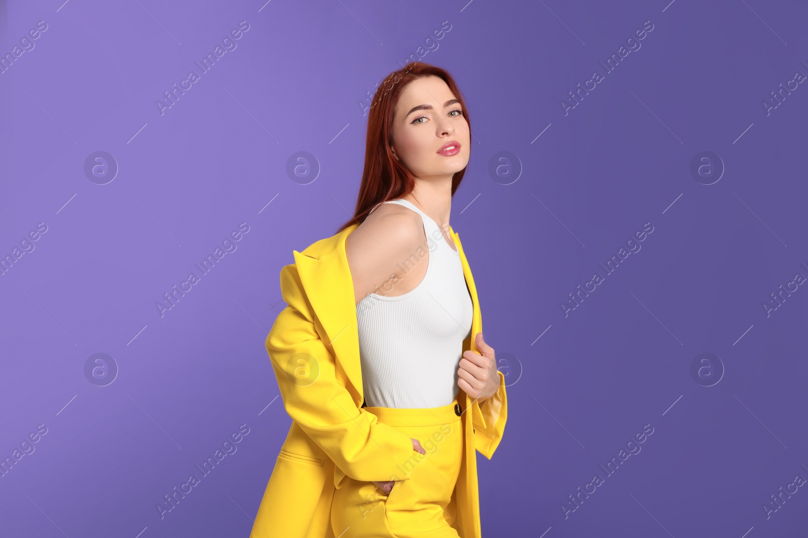 Photo of Stylish woman with red dyed hair on purple background