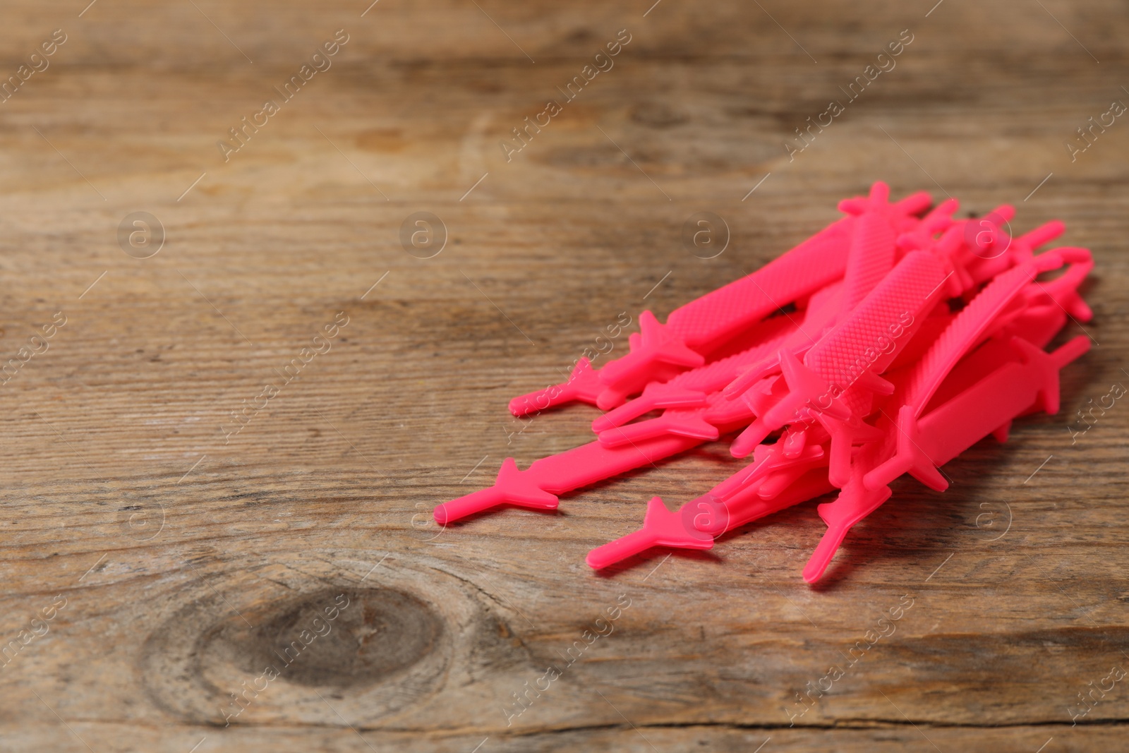 Photo of Pink silicone shoelaces on wooden background. Space for text