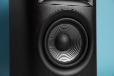 One wooden sound speaker on light blue background, closeup