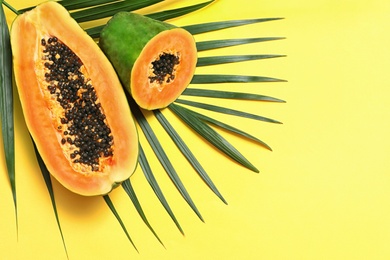 Photo of Flat lay composition with cut papaya on yellow background, space for text