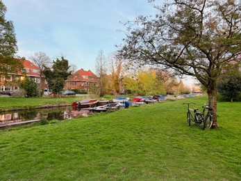 Beautiful view of canal with different boats near green lawn