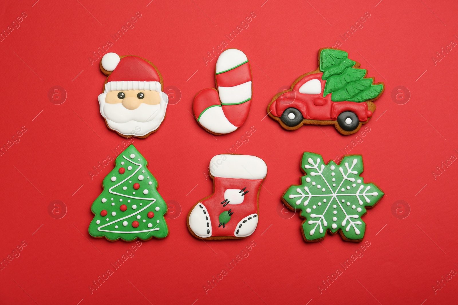 Photo of Different tasty Christmas cookies on red background, flat lay