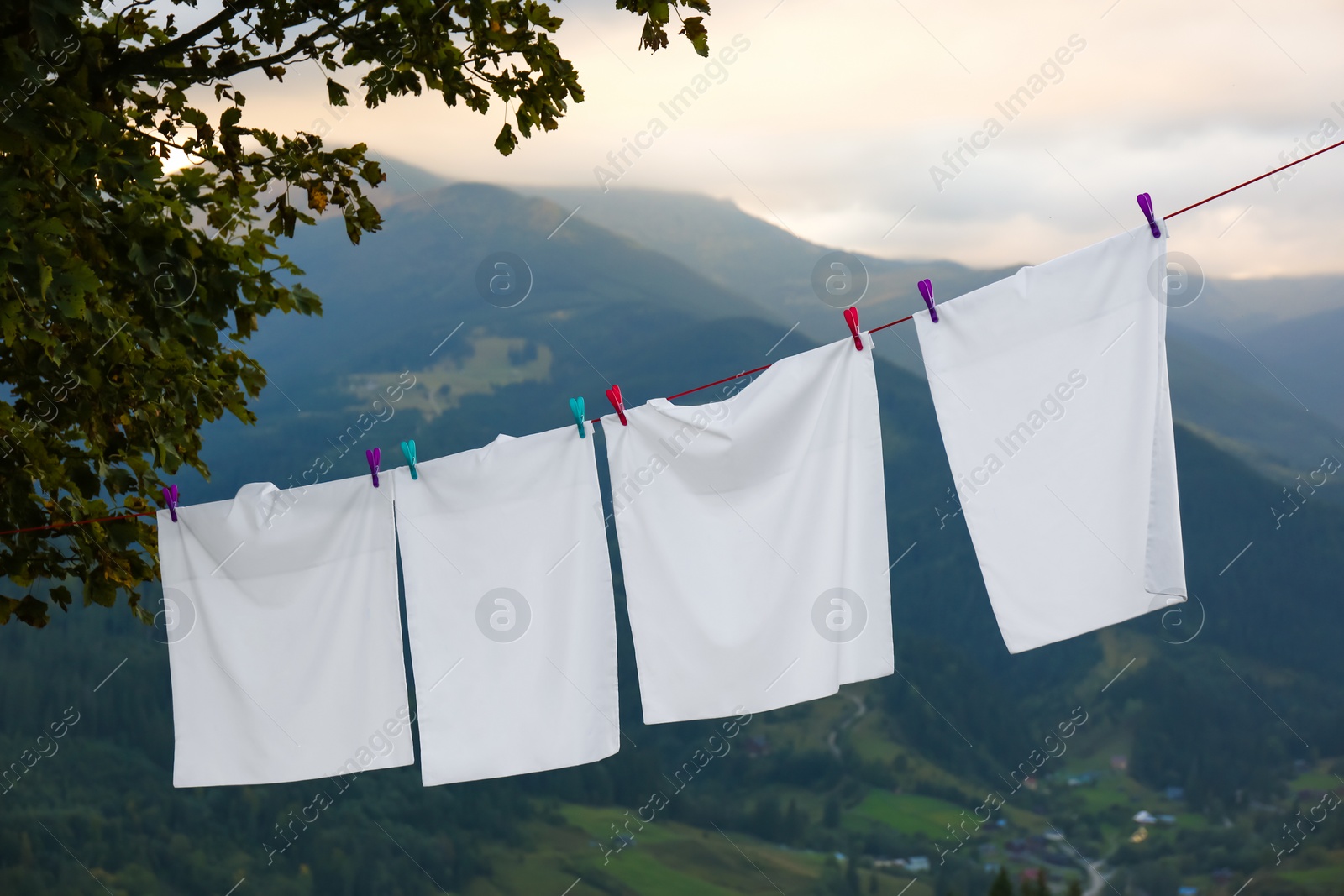 Photo of Bedclothes hanging on washing line in mountains