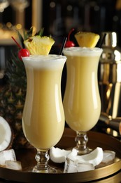 Photo of Tasty Pina Colada cocktails and ingredients on bar countertop