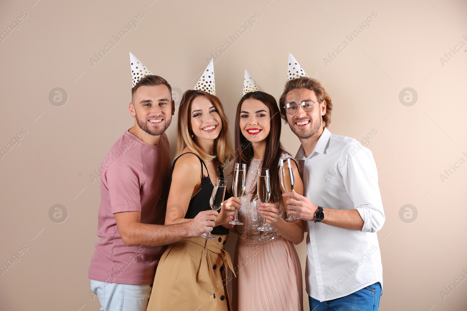 Photo of Portrait of happy friends with champagne in glasses on color background