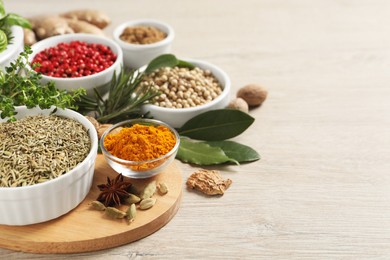 Different herbs and spices on wooden table. Space for text