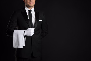 Photo of Butler with towel on black background, closeup. Space for text