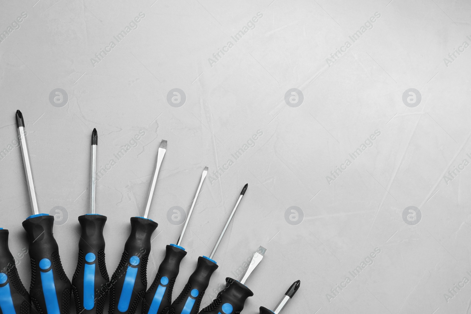 Photo of Set of screwdrivers on light grey background, flat lay. Space for text