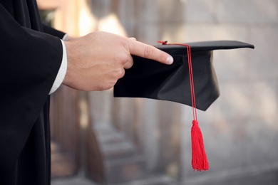 Photo of Male student with graduation hat outdoors, closeup