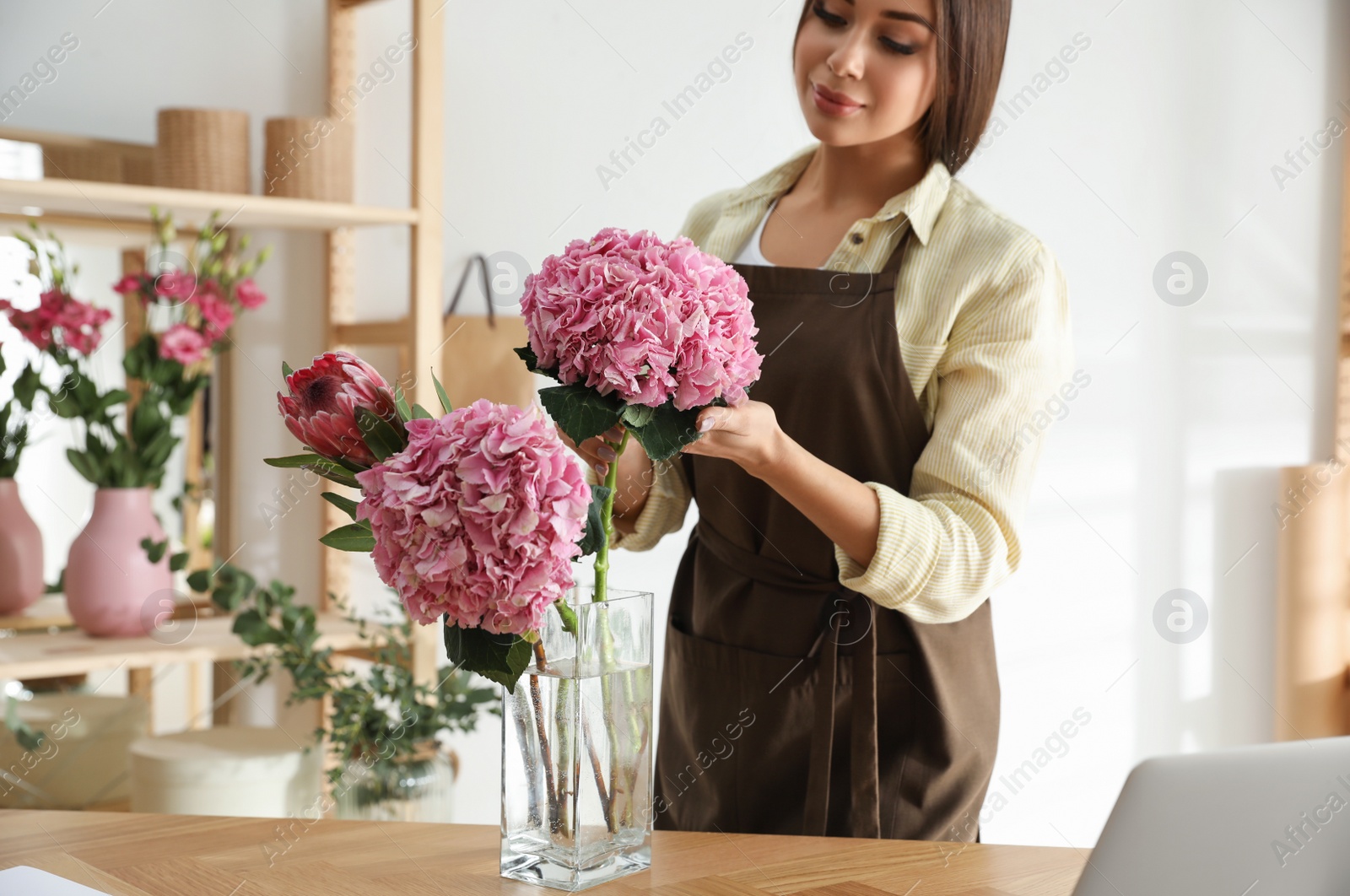 Photo of Florist with beautiful flowers in workshop, closeup