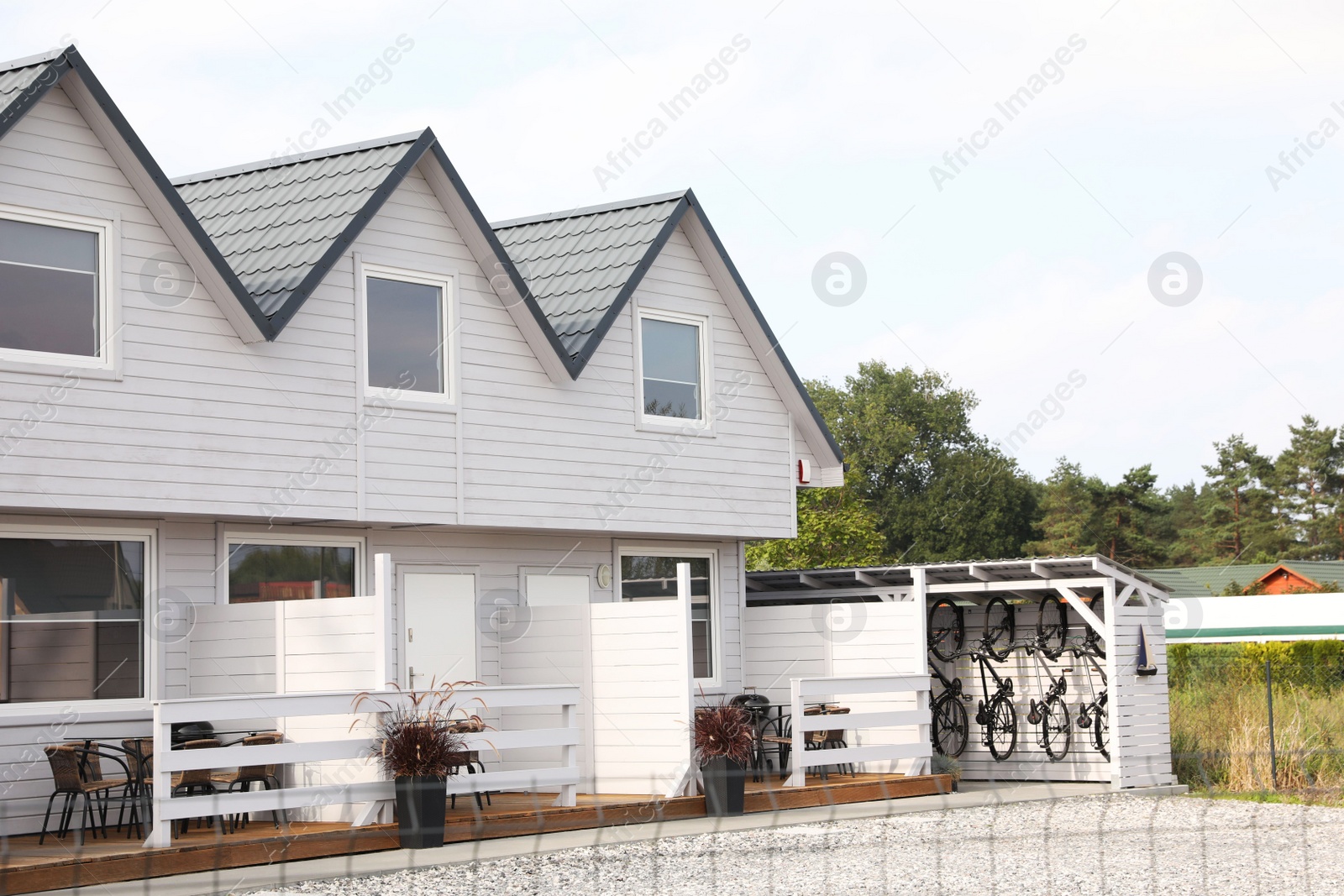 Photo of Beautiful two storey beach house and green trees outdoors