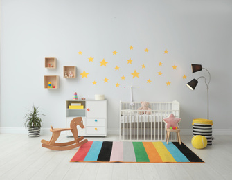 Photo of Stylish baby room interior with crib and toys