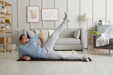 Photo of Overweight man doing exercise on mat at home