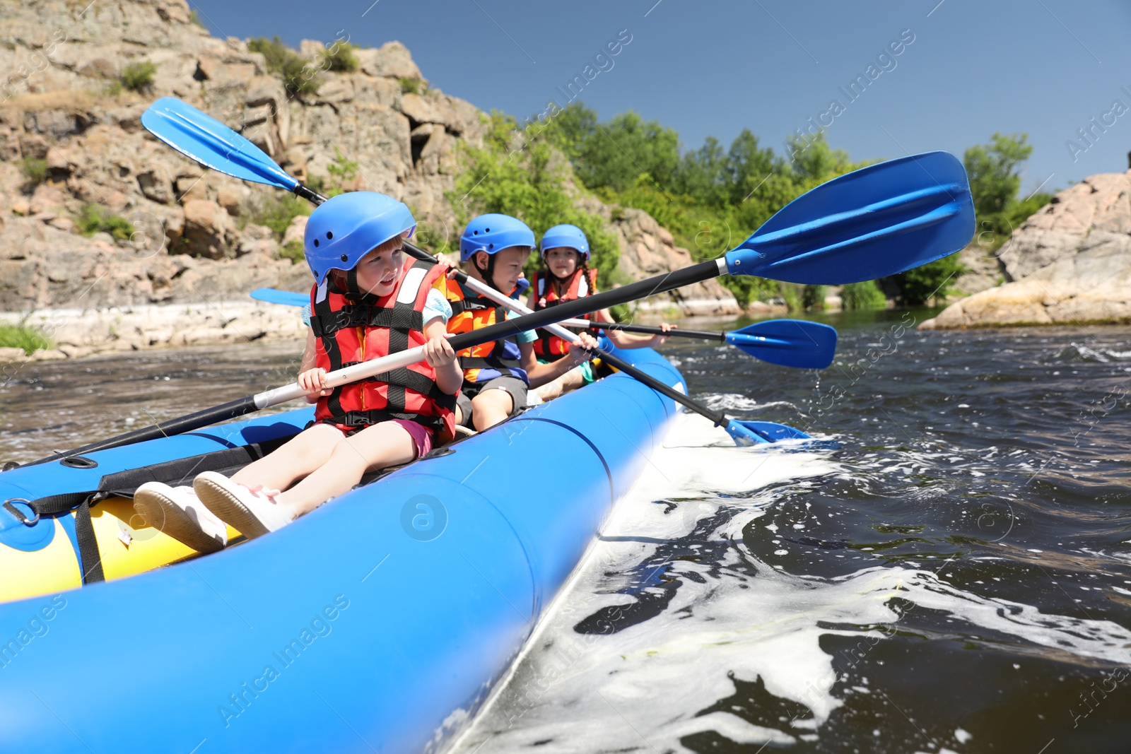 Photo of Little children kayaking on river. Summer camp
