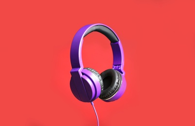 Stylish headphones with pads on color background