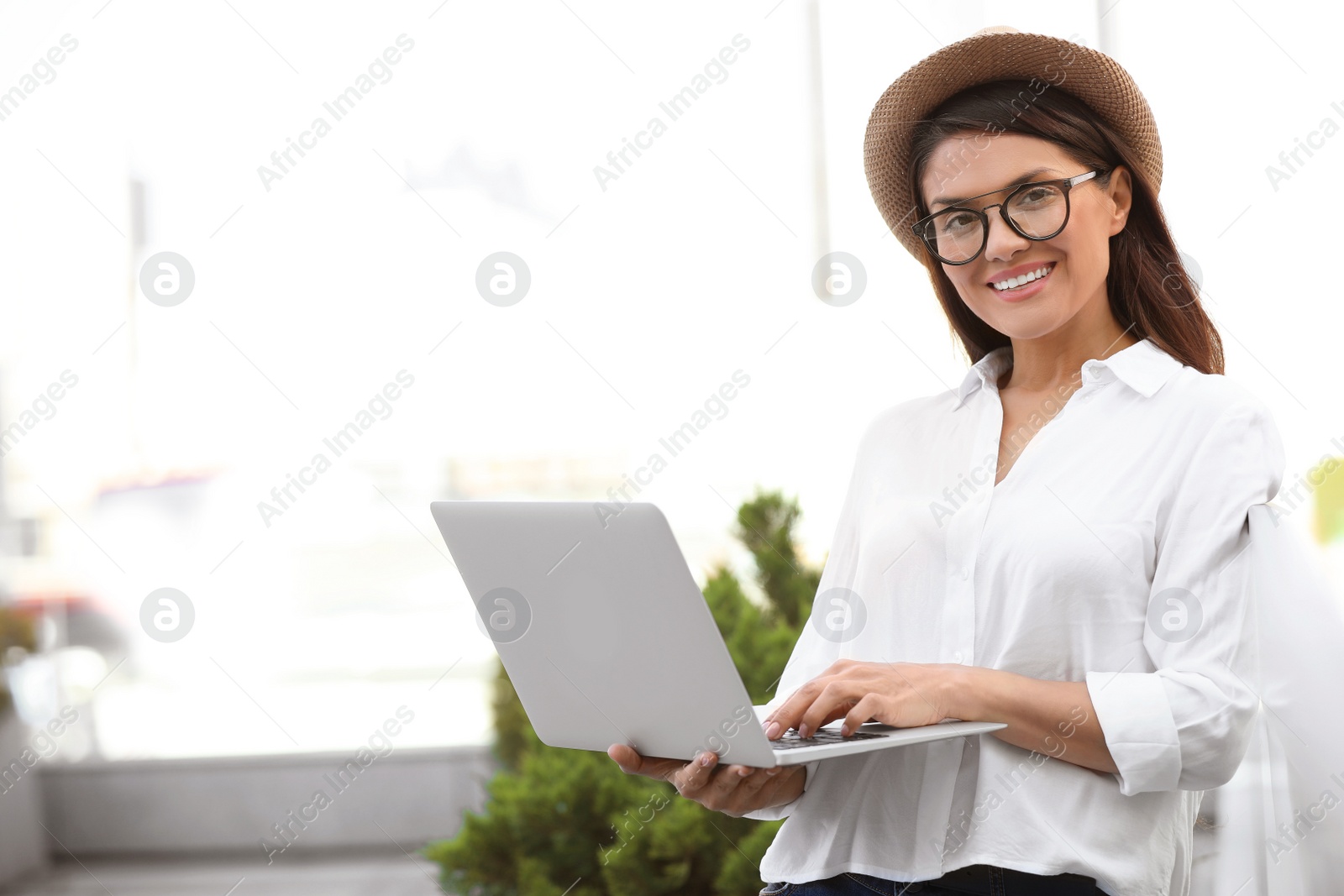 Photo of Beautiful woman with using laptop on city street