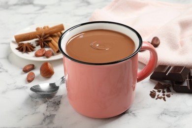 Photo of Yummy hot chocolate in mug on white marble table