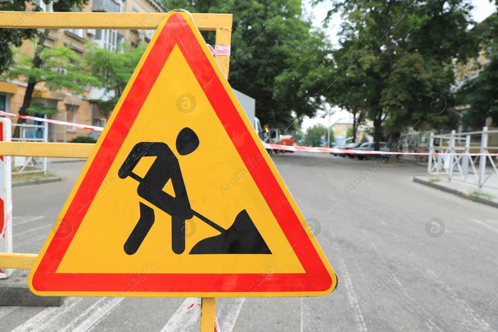 Photo of Barricade with road construction sign on city street. Repair works