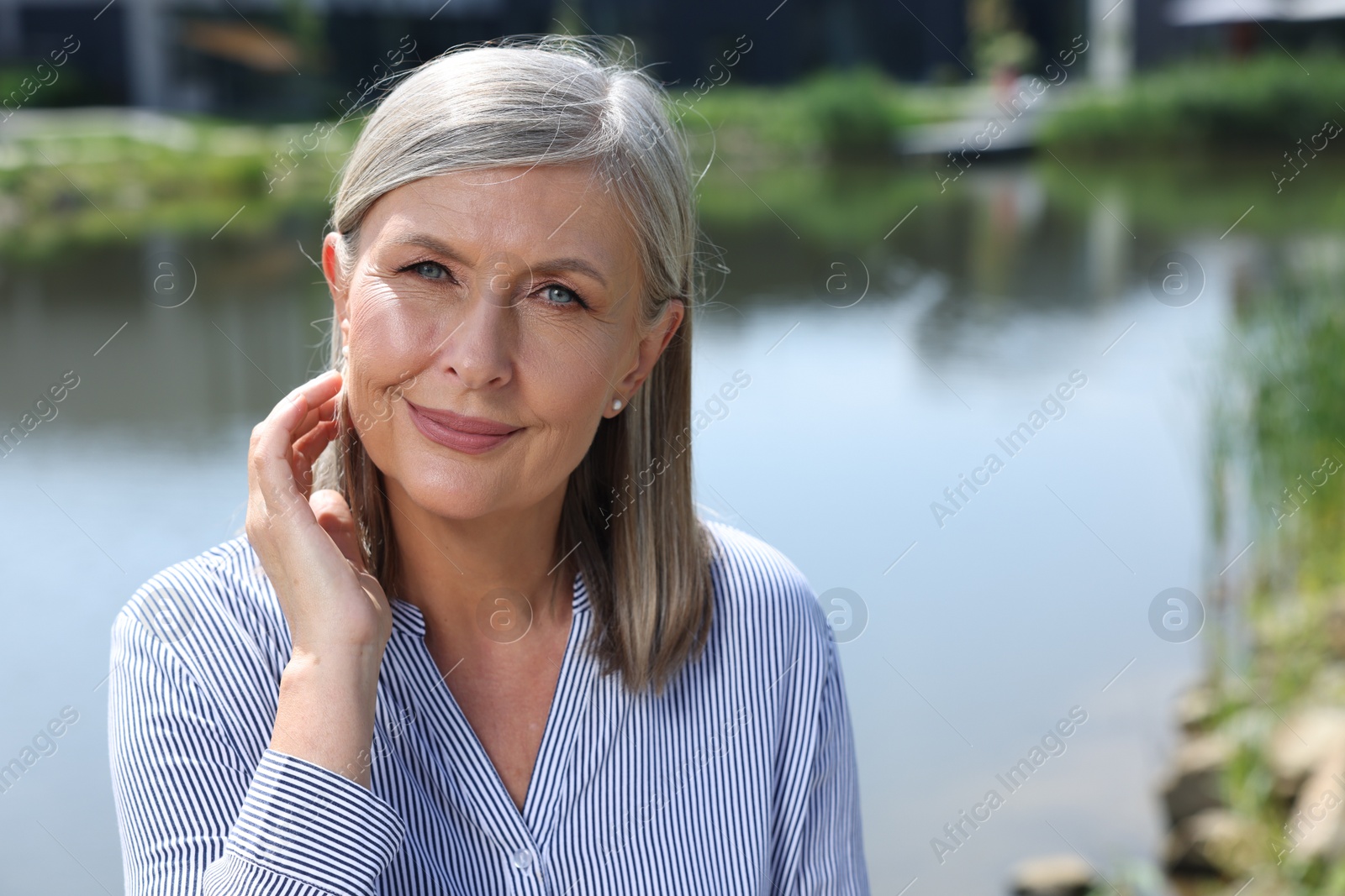 Photo of Portrait of beautiful smiling senior woman outdoors, space for text