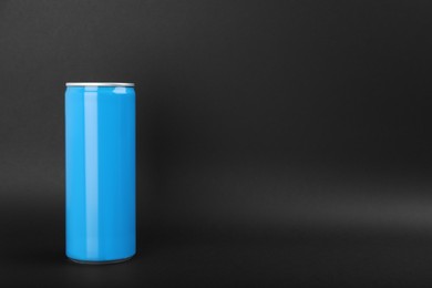Photo of Light blue can of energy drink on black background. Space for text