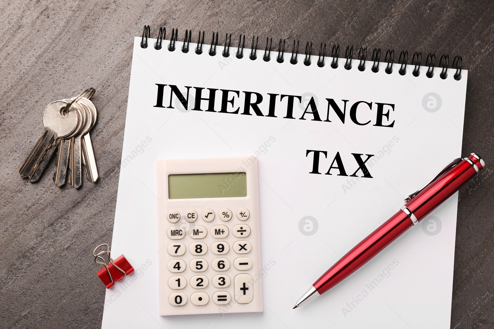 Photo of Inheritance Tax. Notebook, keys and office stationery on grey table, flat lay