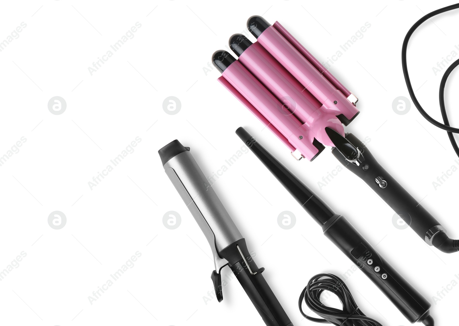 Image of Different hair curling irons on white background, top view