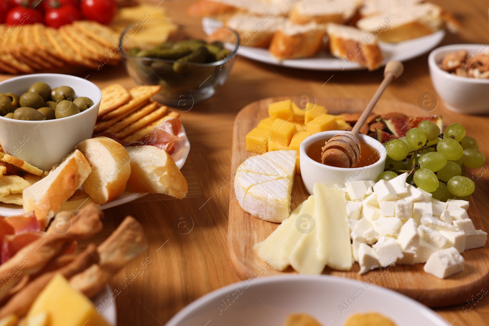 Photo of Assorted appetizers served on wooden table, closeup