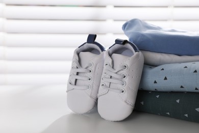 Baby clothes and shoes on light table