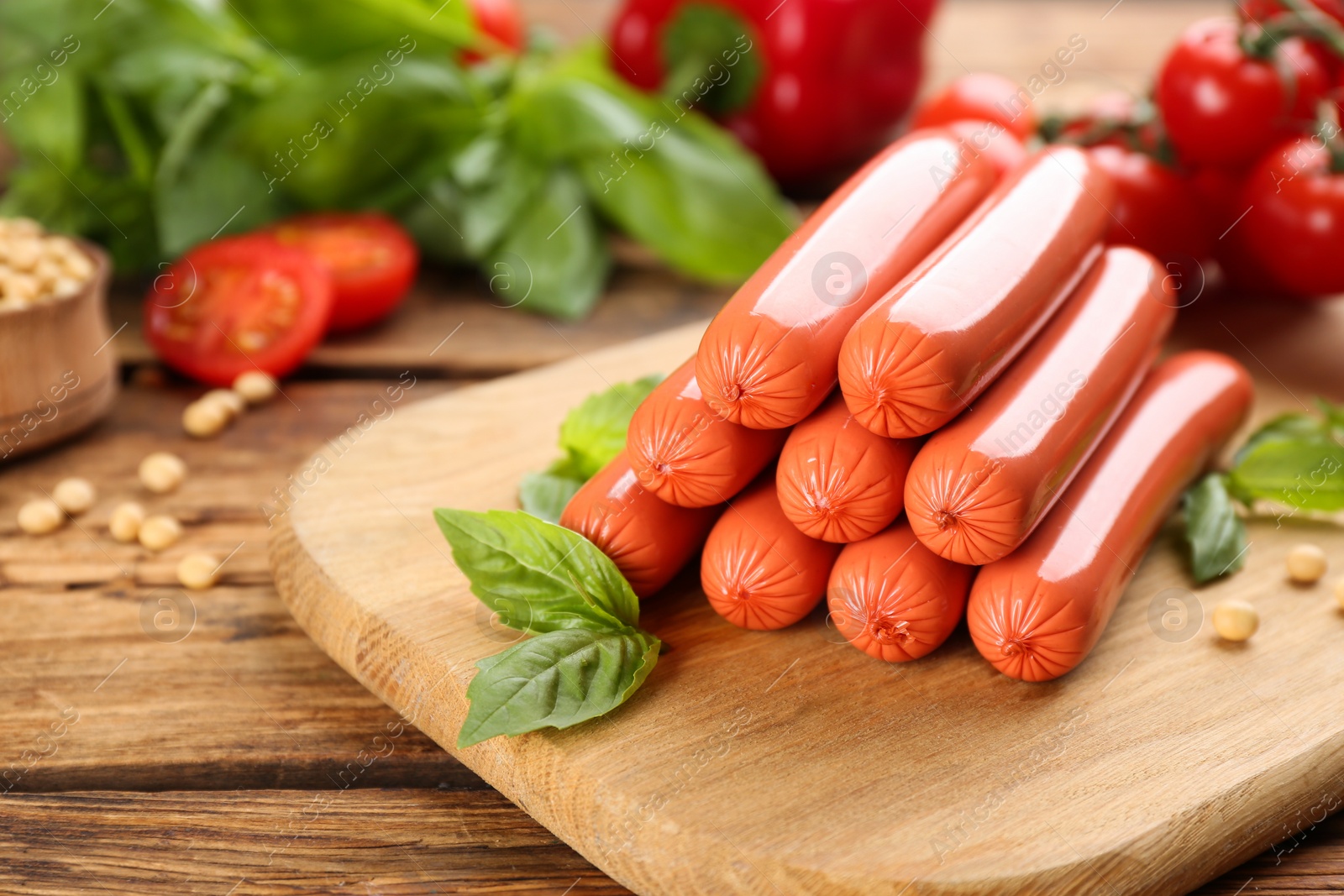 Photo of Fresh raw vegetarian sausages and basil on wooden table. Space for text