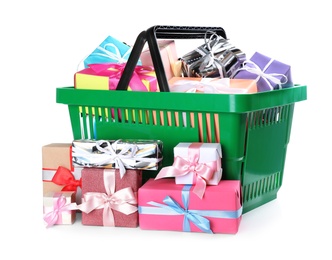 Green shopping basket with different gifts on white background