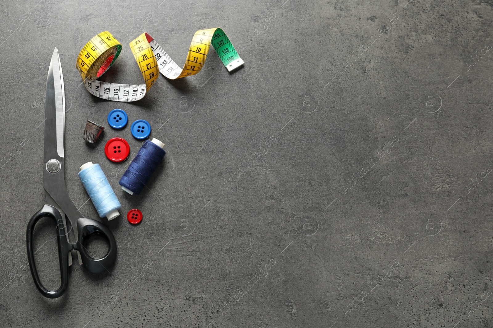 Photo of Set of tailoring accessories on grey background, top view