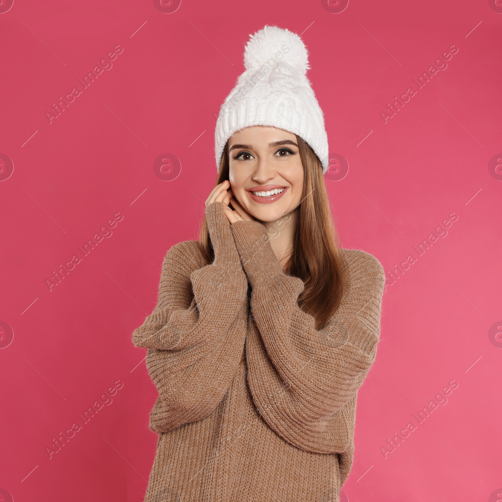 Photo of Beautiful young woman in hat and sweater on pink background. Winter season