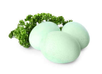 Photo of Turquoise Easter eggs painted with natural dye and curly parsley on white background