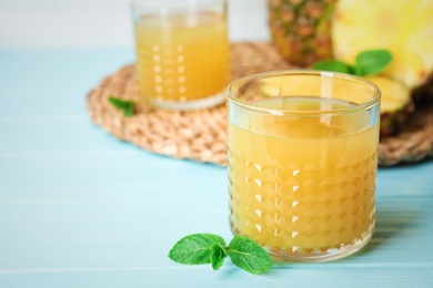 Photo of Glass with delicious pineapple juice on table