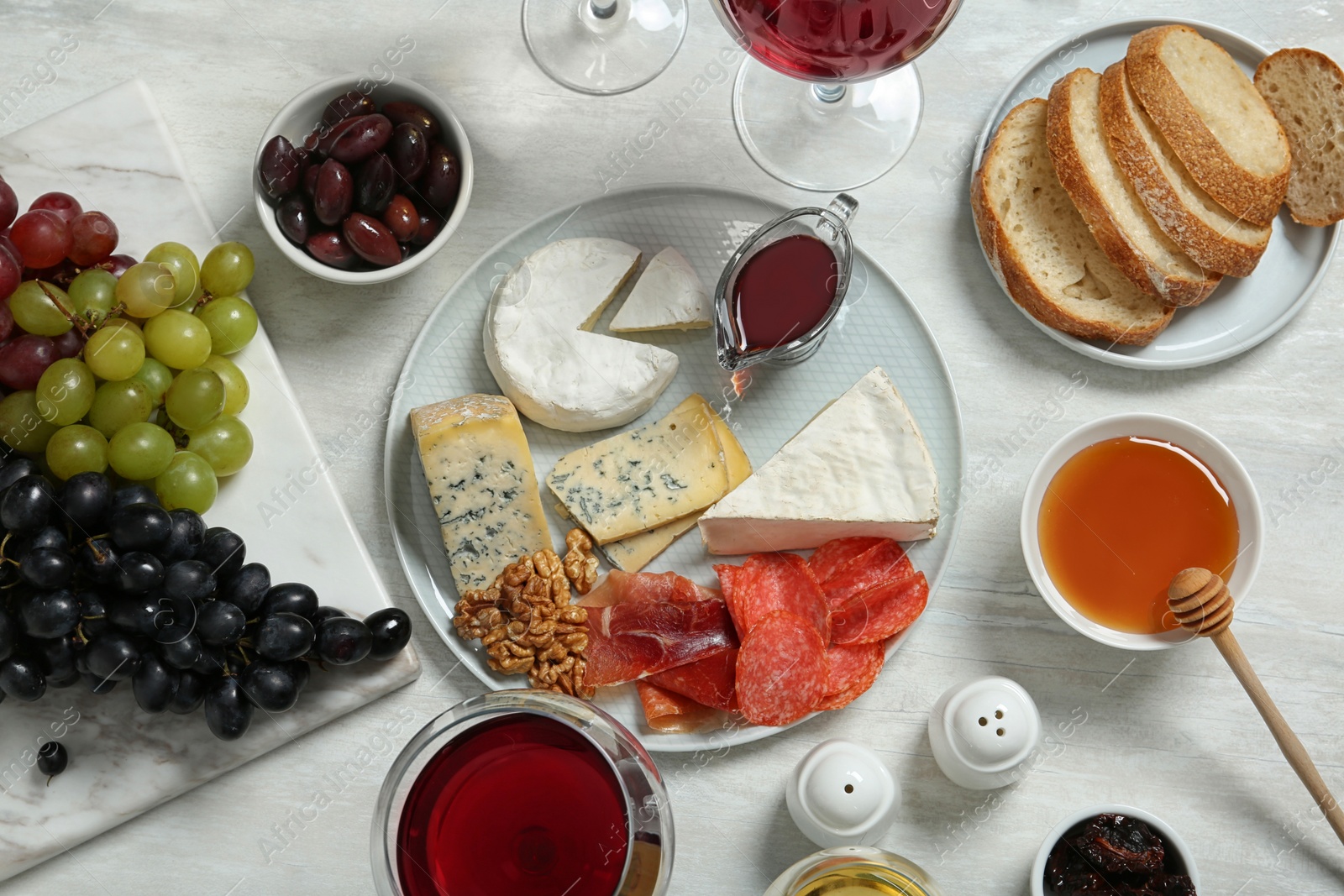 Photo of Wine and snacks served for dinner on light table, flat lay