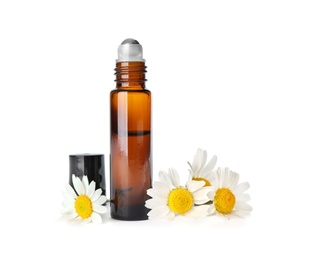Photo of Bottle of herbal essential oil and chamomile flowers isolated on white
