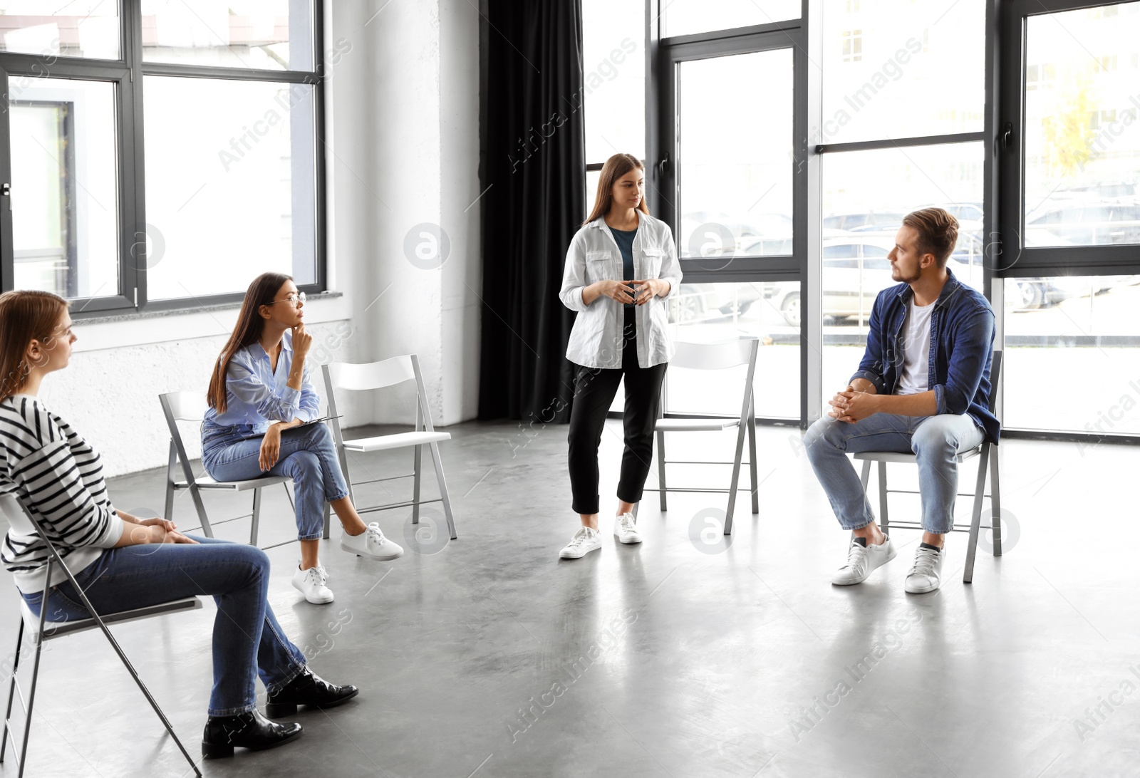 Photo of Psychotherapist working with patients in group therapy session indoors