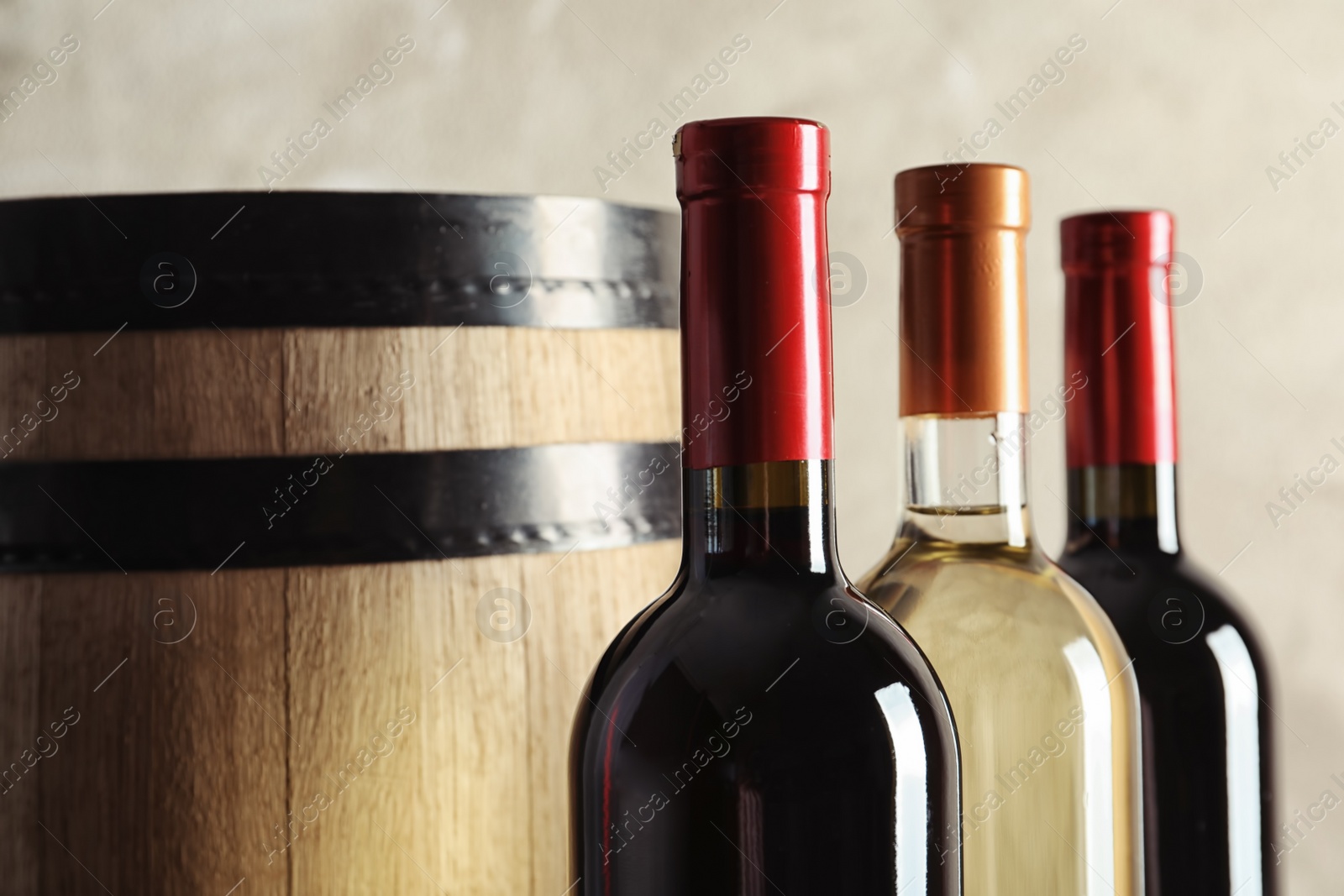 Photo of Bottles with delicious wine on light background, closeup